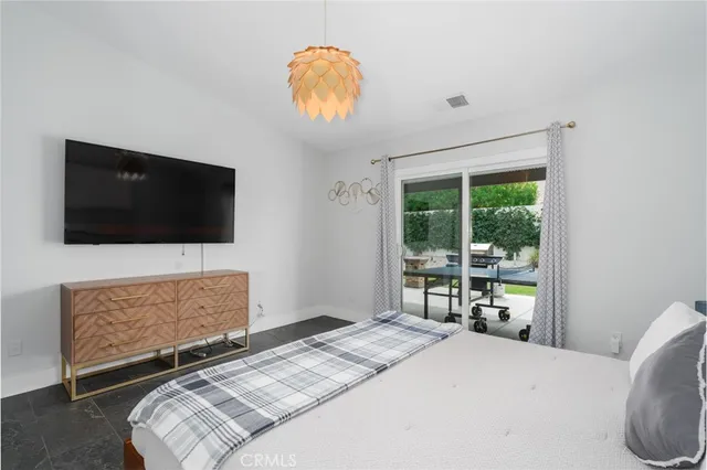 a bedroom with a bed and a flat screen tv