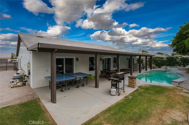a view of a house with backyard barbeque and outdoor seating