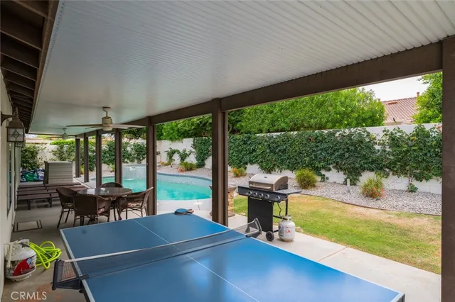 a view of a patio with chairs and floor to ceiling window