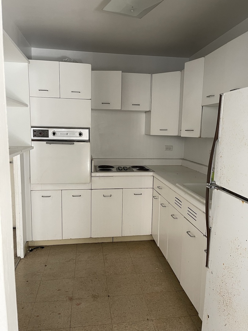6301 North Sheridan Road, Unit 8P Chicago, IL 60660 - Photo 3 of 9 a kitchen with white cabinets and white appliances