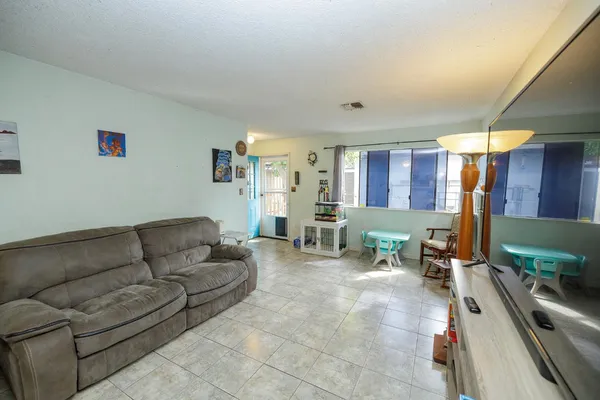 a living room with furniture and a dining table with projector the view