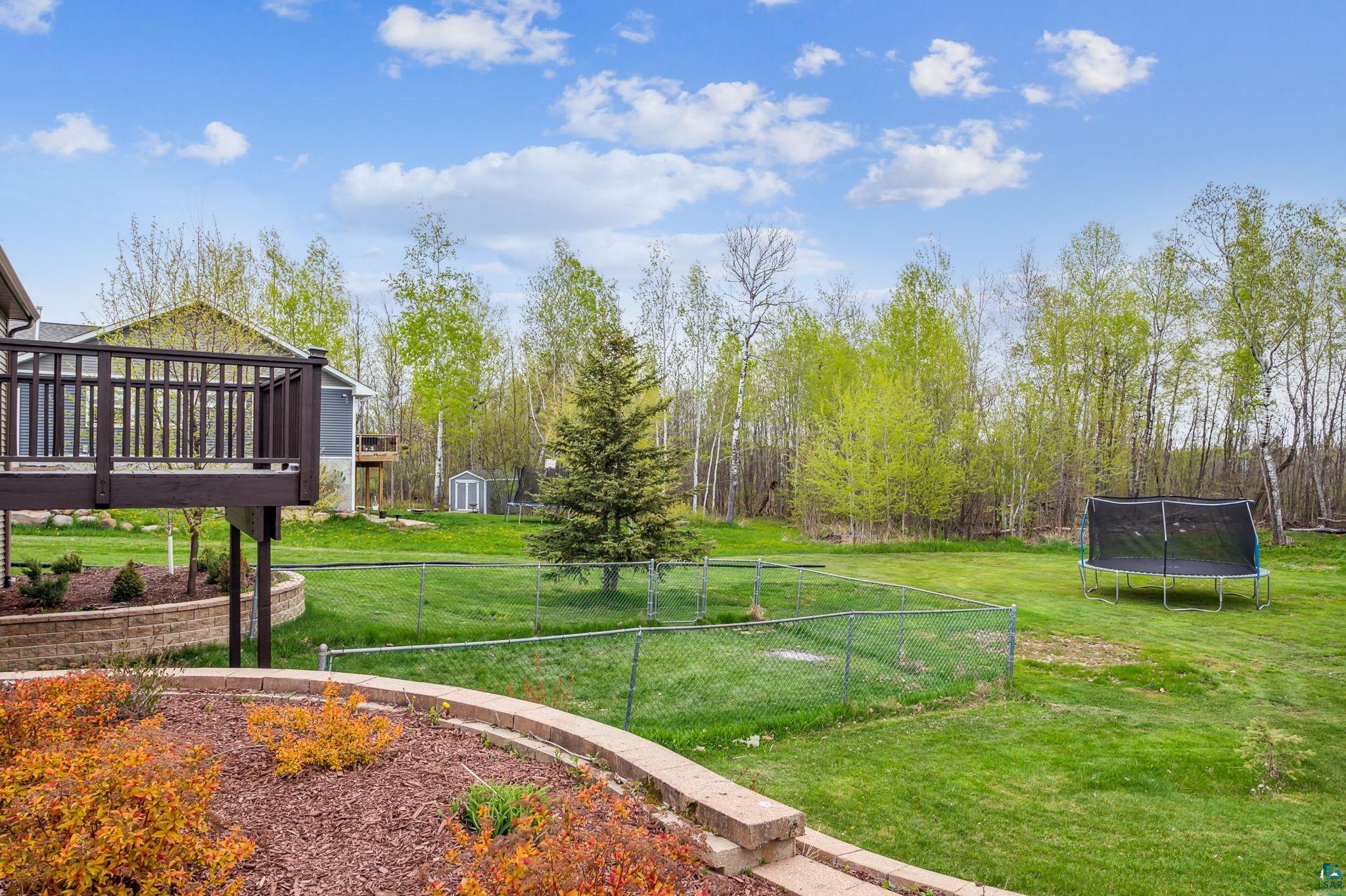 4372 Ugstad Road Hermantown, MN 55811 - Photo 14 of 21 View of yard featuring a trampoline and a wooden deck