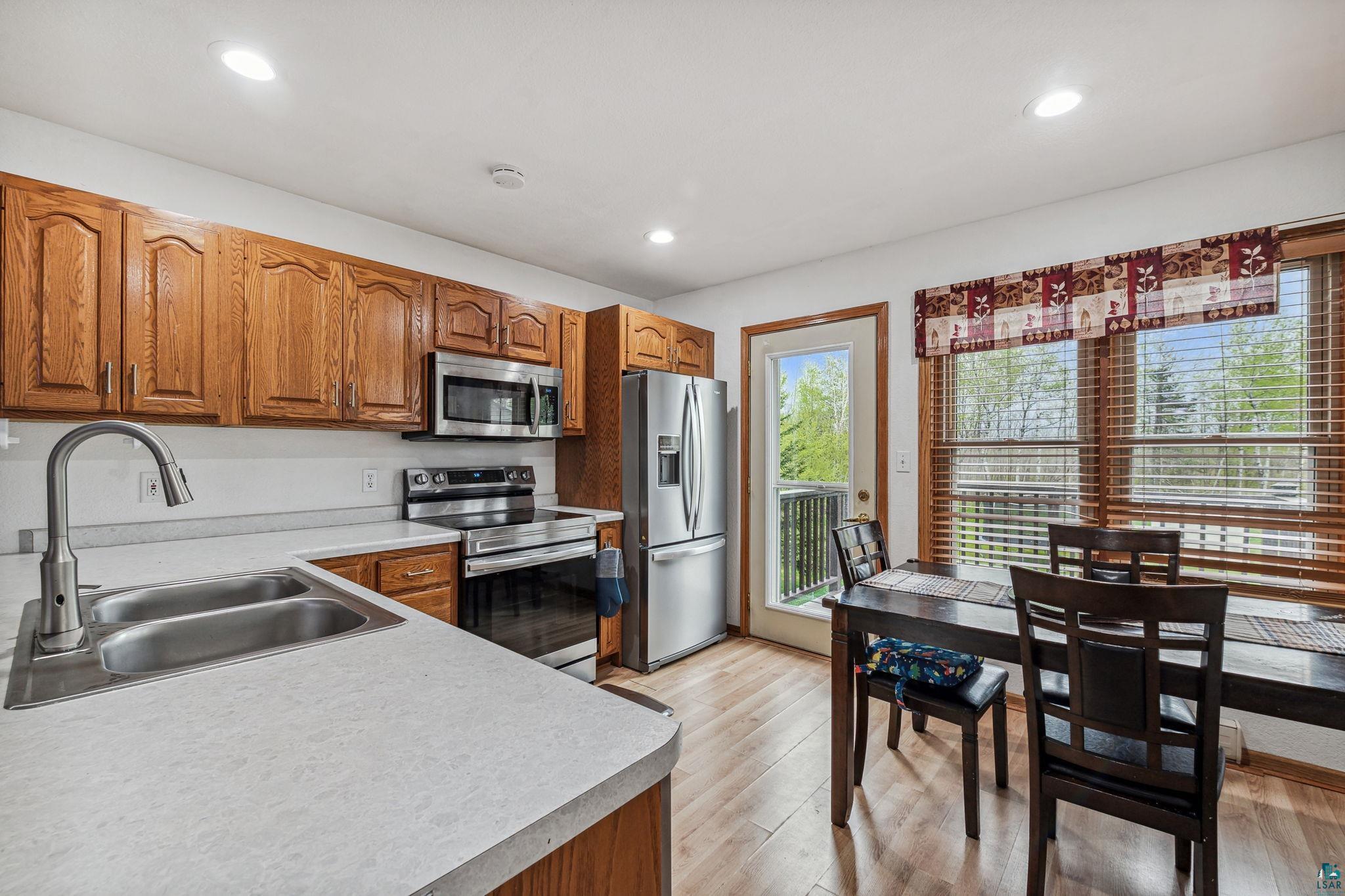 Kitchen with stainless steel appliances, light hardwood / wood-style floors, and sink