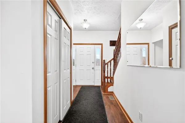 a view of a hallway with wooden floor and staircase