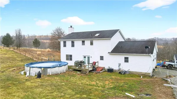 a view of a white house with a swimming pool and a yard