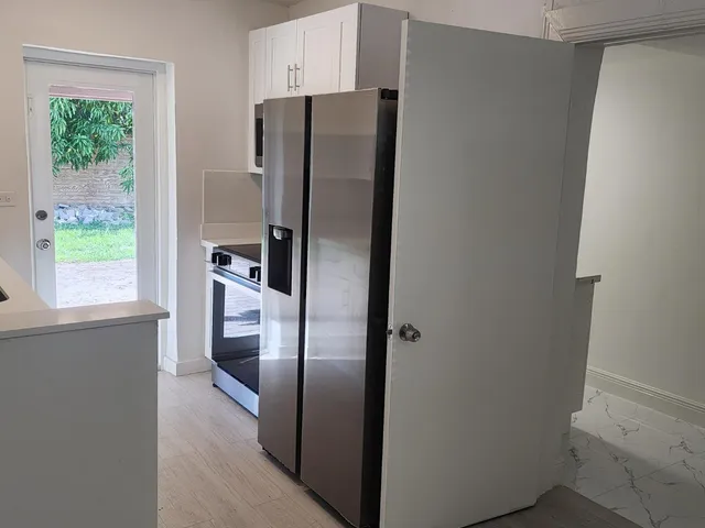 a metallic refrigerator freezer sitting inside of a kitchen