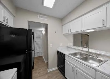 a kitchen with stainless steel appliances granite countertop a sink and a refrigerator