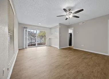 an empty room with ceiling fan and window