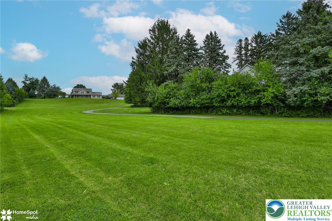 829 Georgetown Road Nazareth, PA 18064 - Photo 6 of 54 Manicured green lawn rolls gently toward a distant estate bordered by mature evergreens.