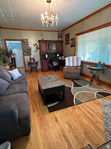 8320 West 3100th Street South Magna, UT 84044 - Photo 10 of 41 Living room with ornamental molding, light wood-style floors, and a chandelier