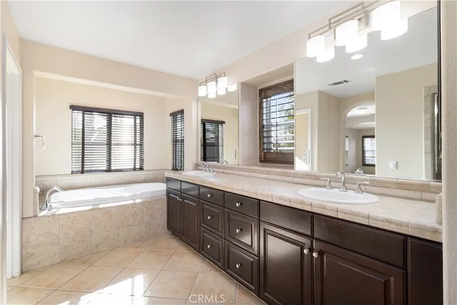 a bathroom with a tub sink and mirror