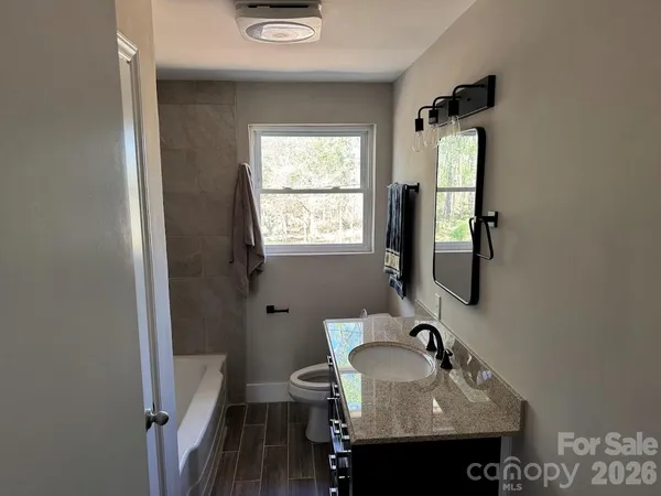 a bathroom with a sink a toilet and mirror