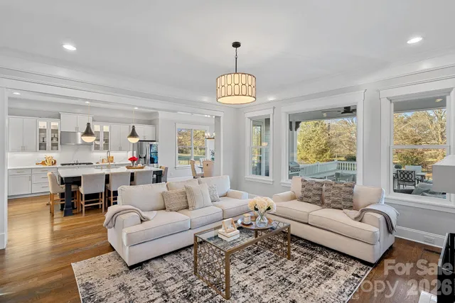 a living room with furniture or couches and a dining table with wooden floor