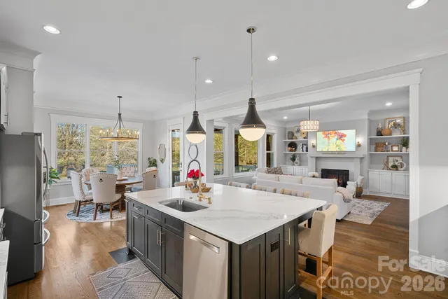 a kitchen with a stove a refrigerator a sink dishwasher with a dining table and chairs