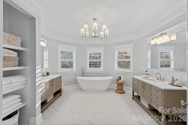 a spacious bathroom with double vanity and a bathtub