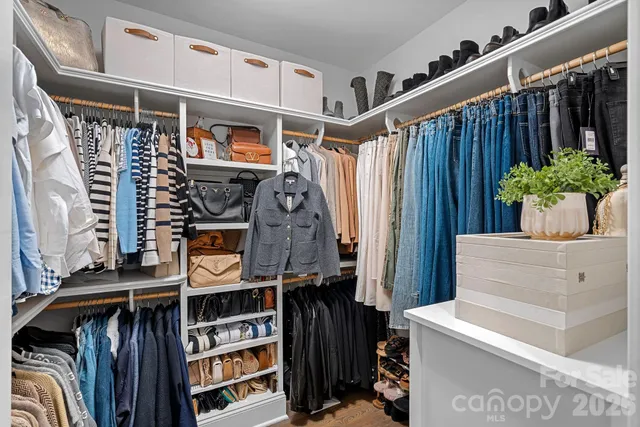 a view of walk in closet with clothes and shoes
