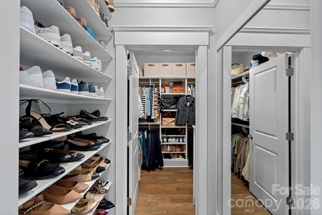 a view of walk in closet with clothes and shoes