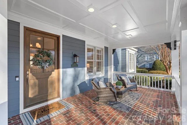 a living room with furniture large window and wooden floor