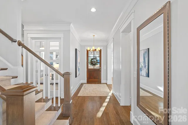 a view of a hallway with wooden floor and staircase
