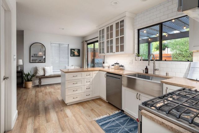 a kitchen with a stove a sink and a window