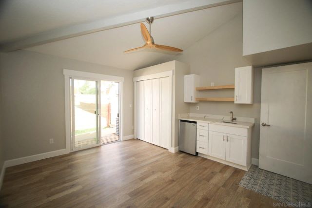 a kitchen with granite countertop a stove a sink and a refrigerator