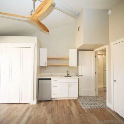 a view of a kitchen with a sink and a refrigerator