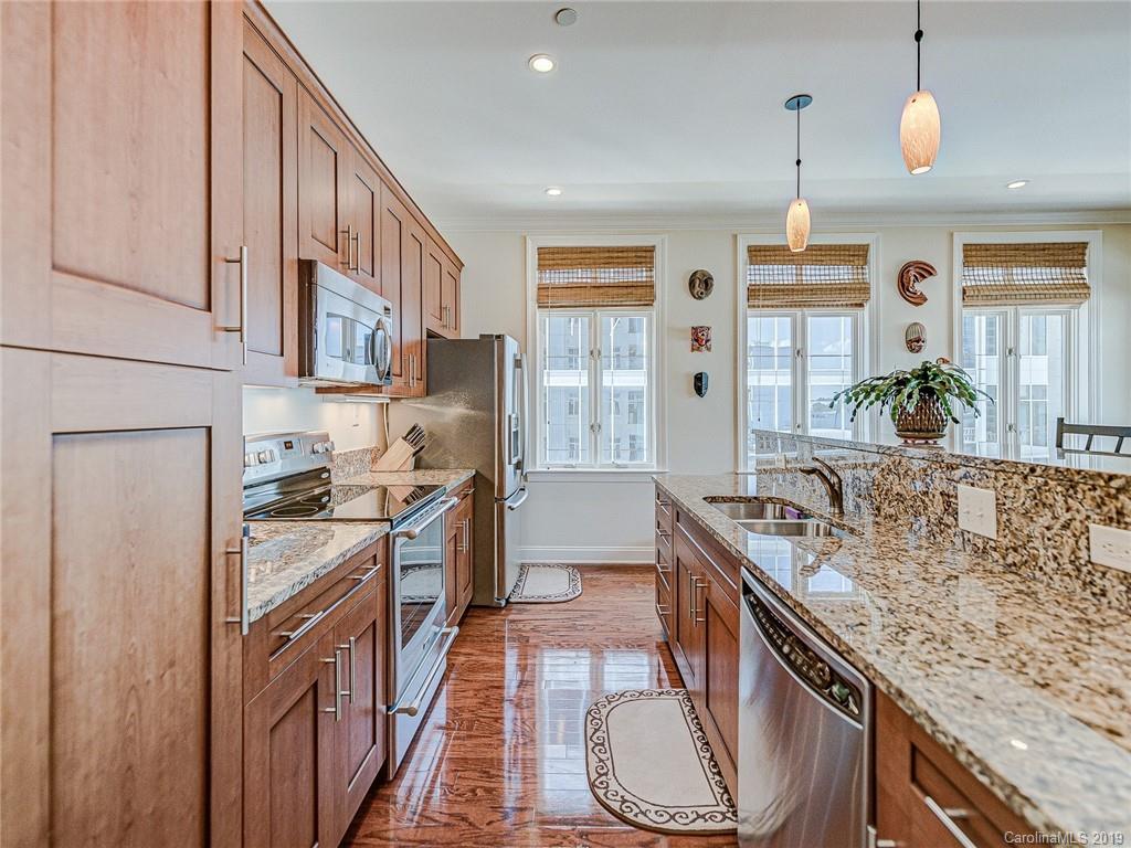 230 South Tryon Street, Unit 710 Charlotte, NC 28202 - Photo 12 of 48 a kitchen with stainless steel appliances granite countertop a sink stove and refrigerator