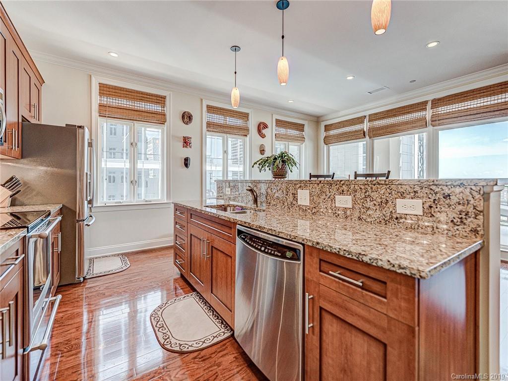 230 South Tryon Street, Unit 710 Charlotte, NC 28202 - Photo 13 of 48 a kitchen with stainless steel appliances granite countertop a stove a sink and a refrigerator