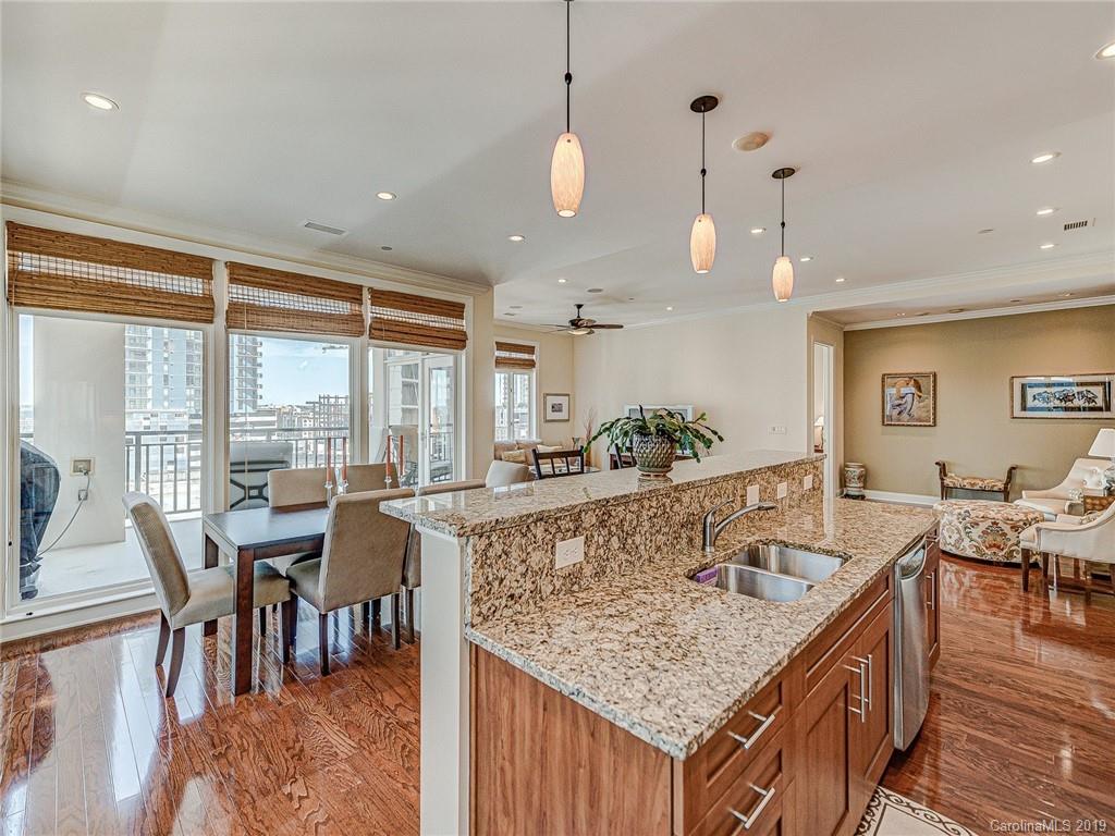 230 South Tryon Street, Unit 710 Charlotte, NC 28202 - Photo 15 of 48 a view of center island of a kitchen with granite countertop living room and living room