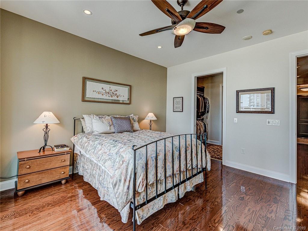 230 South Tryon Street, Unit 710 Charlotte, NC 28202 - Photo 21 of 48 a bed room with a bed and a ceiling fan