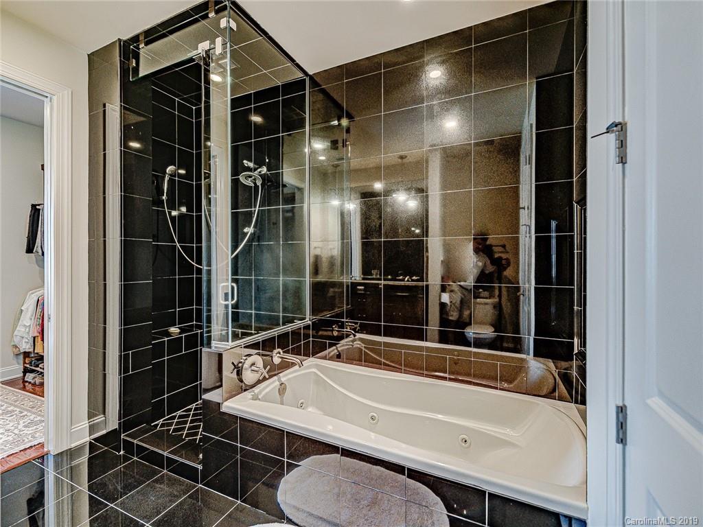 230 South Tryon Street, Unit 710 Charlotte, NC 28202 - Photo 24 of 48 a bathroom with a granite countertop sink a toilet and shower