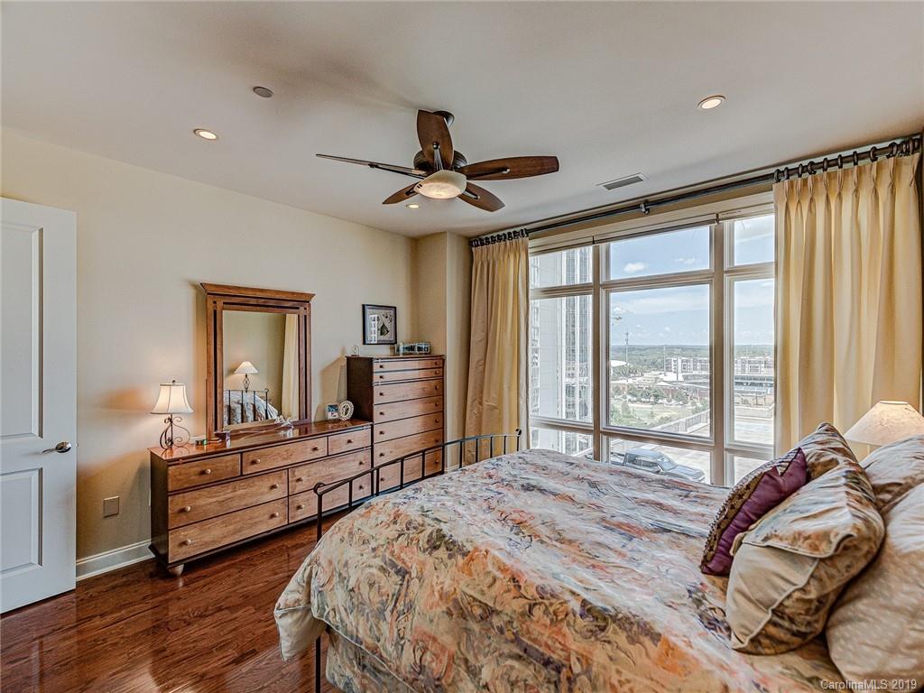 230 South Tryon Street, Unit 710 Charlotte, NC 28202 - Photo 27 of 48 a bedroom with a bed and a chandelier