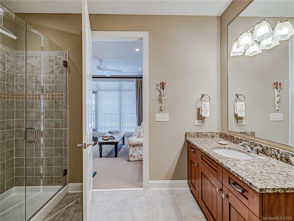 230 South Tryon Street, Unit 710 Charlotte, NC 28202 - Photo 29 of 48 a bathroom with a granite countertop sink a mirror and a bathtub