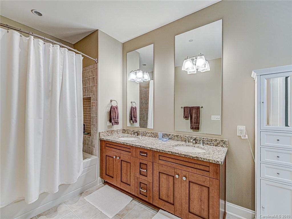 230 South Tryon Street, Unit 710 Charlotte, NC 28202 - Photo 32 of 48 a bathroom with a granite countertop sink and a mirror