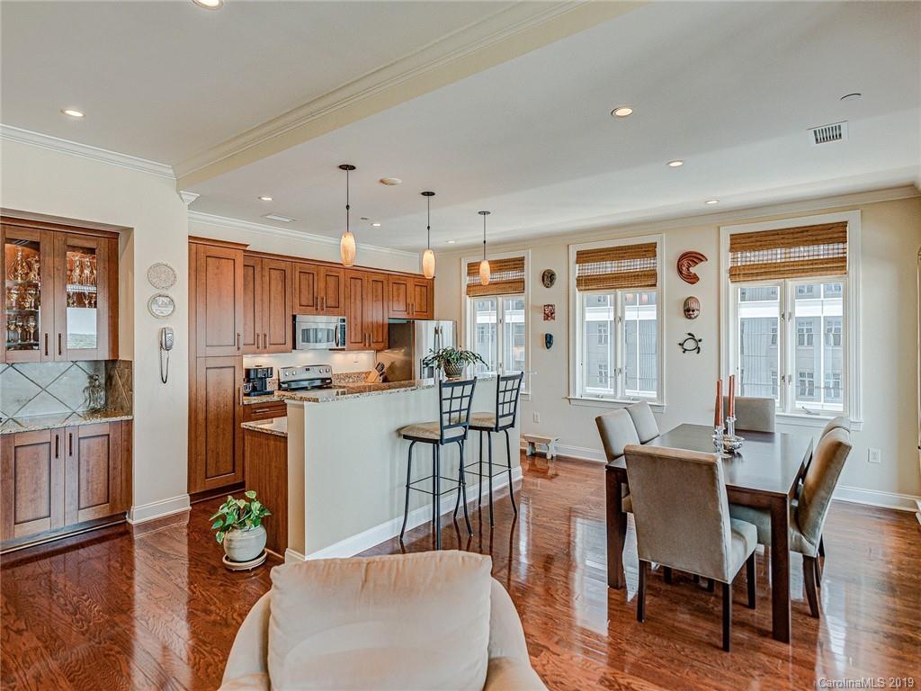 230 South Tryon Street, Unit 710 Charlotte, NC 28202 - Photo 9 of 48 a view of a dining room with furniture window and wooden floor