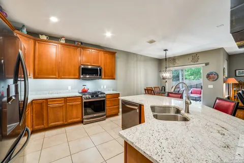 a kitchen with stainless steel appliances granite countertop sink stove top oven and cabinets