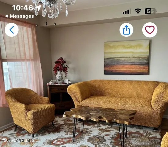 a living room with furniture and a chandelier