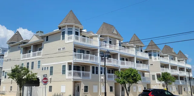 a view of a white building among the street with palm trees