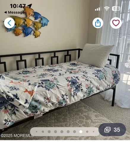 a bedroom with a bed and painting on the wall