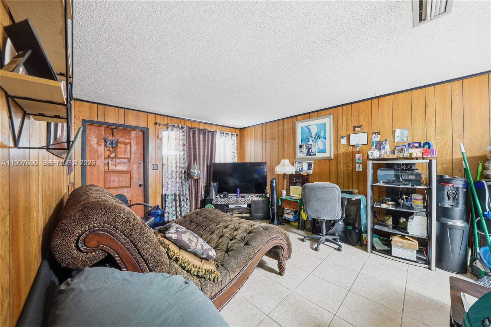 1910 South 34th Street Fort Pierce, FL 34947 - Photo 17 of 24 a living room with furniture a bookshelf and a large window