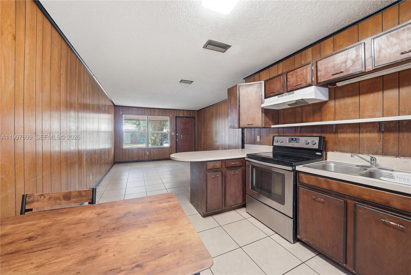 1910 South 34th Street Fort Pierce, FL 34947 - Photo 6 of 24 a kitchen with stainless steel appliances granite countertop a sink and cabinets