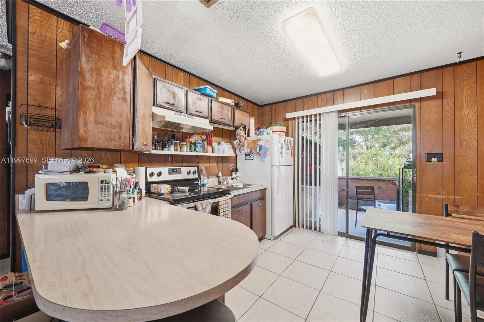 1910 South 34th Street Fort Pierce, FL 34947 - Photo 8 of 24 a kitchen with sink a refrigerator and chairs