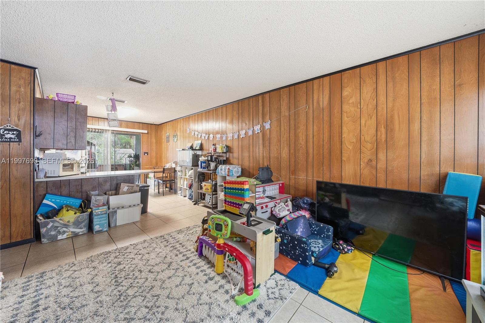 1910 South 34th Street Fort Pierce, FL 34947 - Photo 9 of 24 a living room with furniture and a flat screen tv