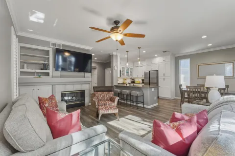 a living room with furniture kitchen area and a large window