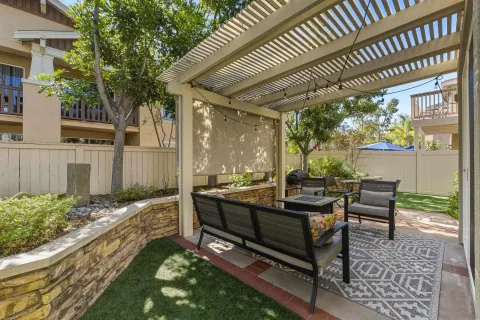 a view of a patio with table and chairs and potted plants with large tree