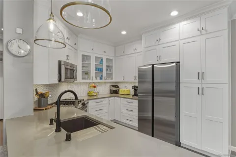 a kitchen with kitchen island a counter top space appliances and cabinets