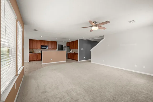a view of a livingroom with a ceiling fan and window