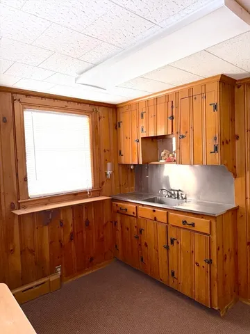 a view of a hallway with wooden floor and cabinet