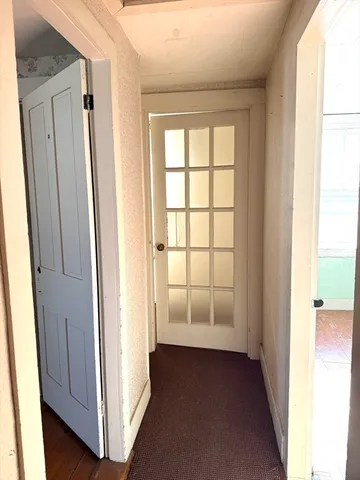 a view of entryway with wooden floor and cabinets
