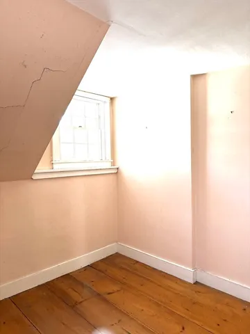 a view of a room with wooden floor and a window